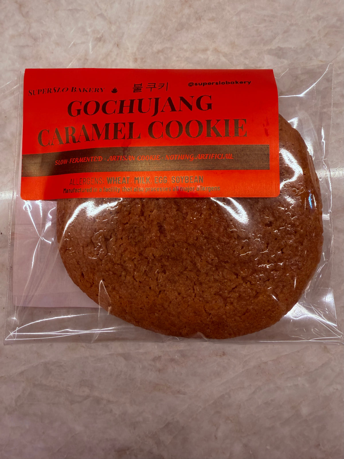 Gochujang caramel cookie from My Store showing a close-up of a baked cookie with a glossy caramel glaze and a hint of red gochujang.