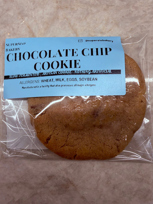 Chocolate chip cookie from SuperSlo Bakery, golden-brown with visible chocolate chunks on a rustic plate.