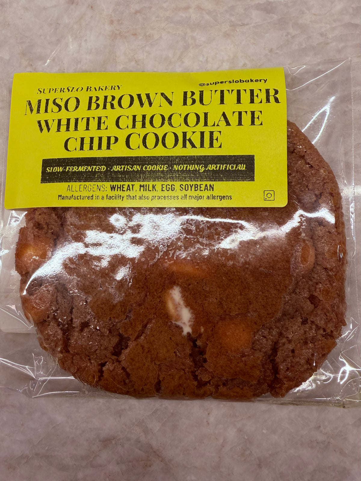 Miso Brown Butter White Chocolate Chip Cookie by SuperSlo Bakery, close-up of a freshly baked cookie with white chocolate chips
