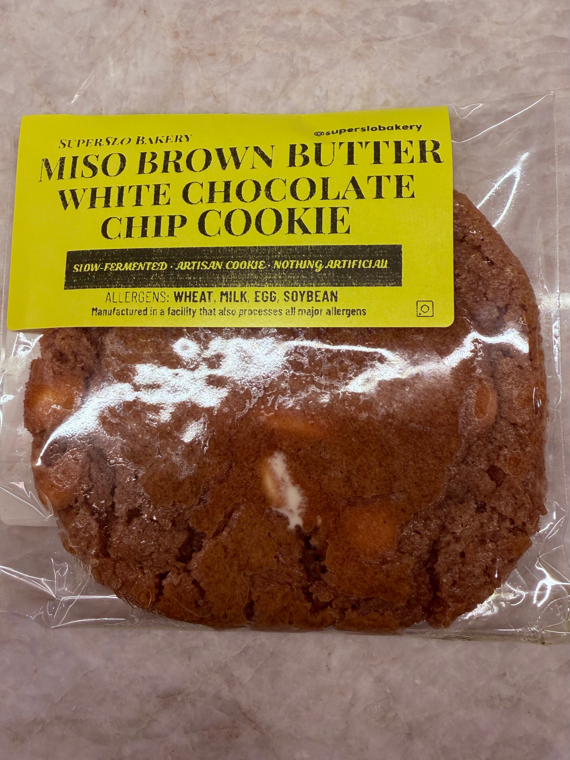 Miso Brown Butter White Chocolate Chip Cookie by SuperSlo Bakery, close-up of a freshly baked cookie with white chocolate chips
